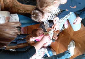 Dzieci oglądają porcelanową lalkę, która należała do Anny Marii Herbst